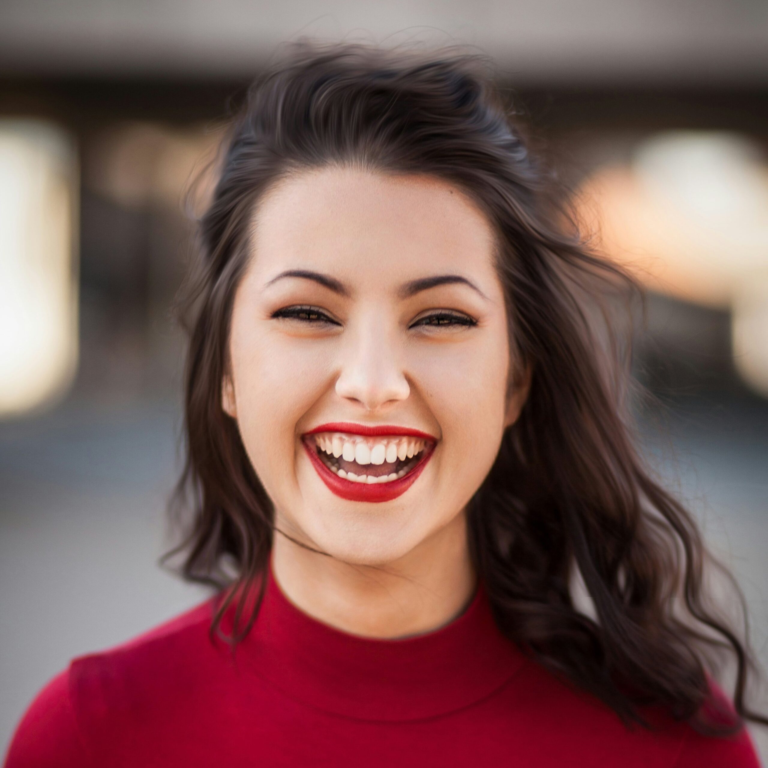 Junge Frau mit dunklen Haaren, roter Lippenstift, lächelnd